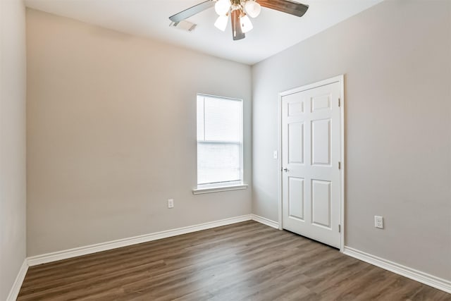 unfurnished room with ceiling fan and dark hardwood / wood-style floors