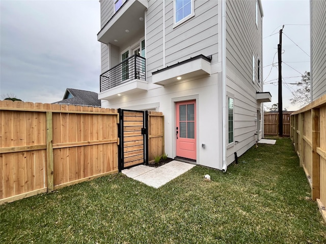 back of property featuring a yard and a balcony