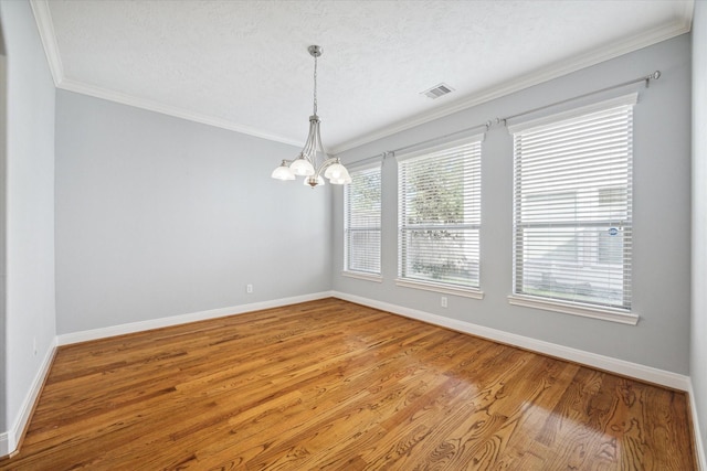 unfurnished room with wood-type flooring, a chandelier, crown molding, and a wealth of natural light