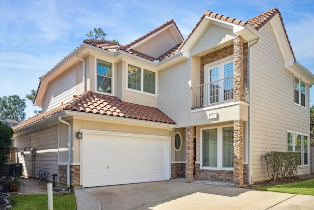 mediterranean / spanish-style home featuring a balcony, a garage, and central AC unit