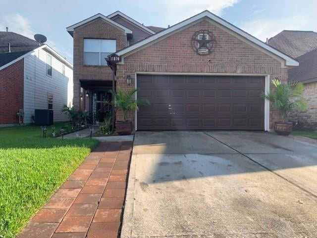 front of property with central air condition unit, a front lawn, and a garage