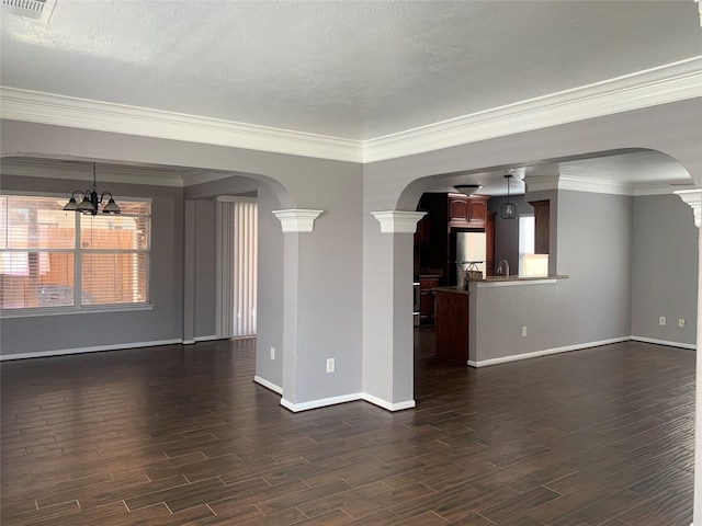 unfurnished living room with decorative columns, an inviting chandelier, ornamental molding, and a textured ceiling