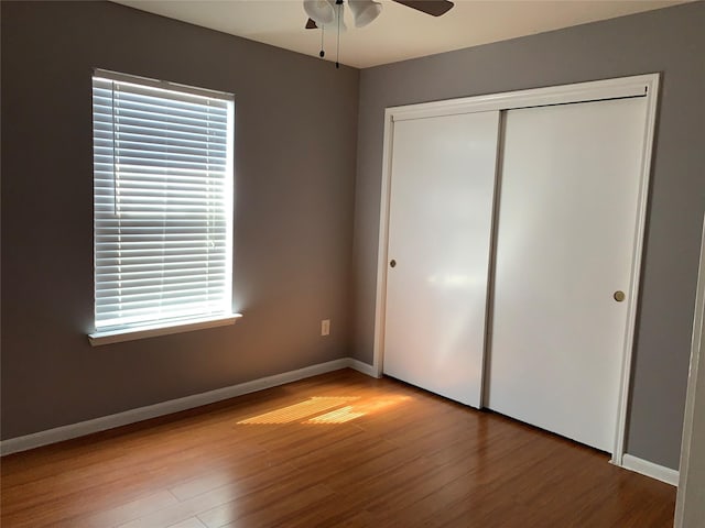 unfurnished bedroom featuring ceiling fan, hardwood / wood-style floors, and a closet