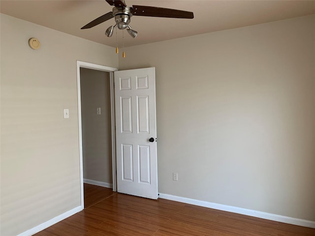 empty room with ceiling fan and dark hardwood / wood-style floors