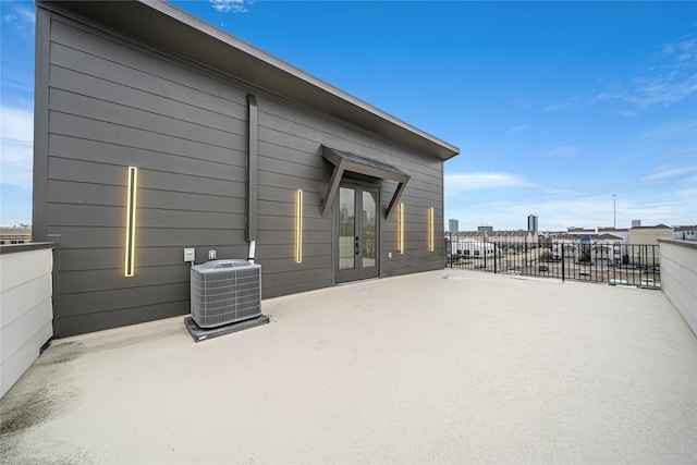 view of side of property with french doors, a patio area, and central AC unit