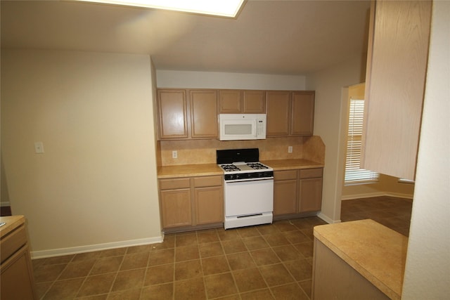 kitchen with light brown cabinetry, decorative backsplash, and white appliances