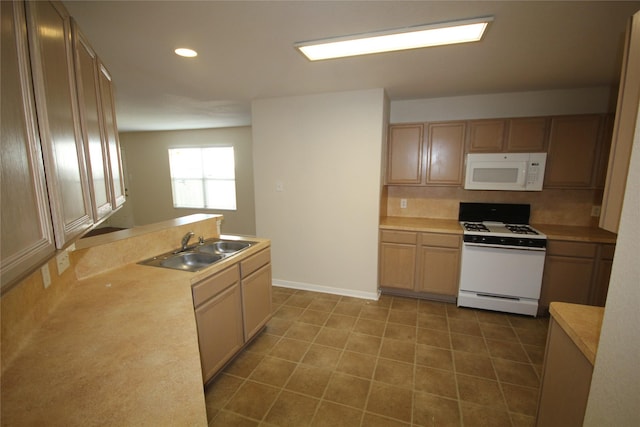 kitchen featuring backsplash, sink, and white appliances