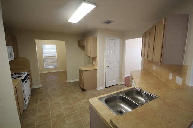 kitchen featuring light brown cabinetry, sink, white appliances, and decorative backsplash