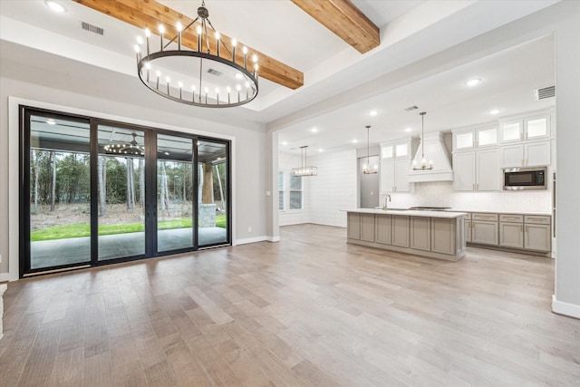 interior space with sink, light hardwood / wood-style flooring, and beamed ceiling