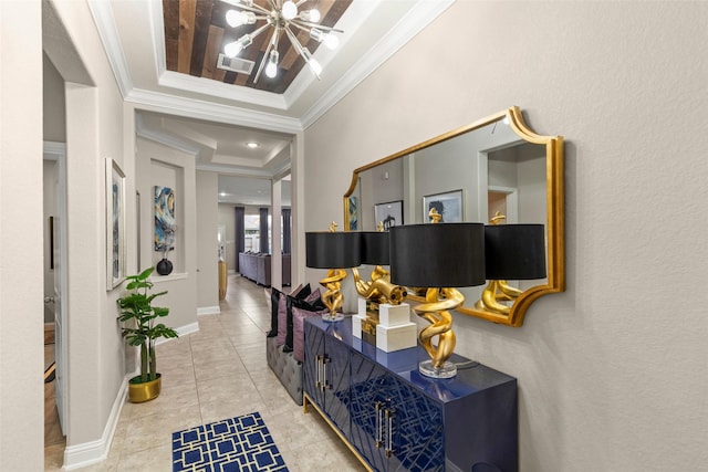 hallway featuring a tray ceiling, a chandelier, light tile patterned floors, and crown molding