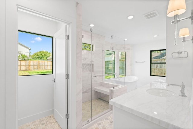 bathroom with a healthy amount of sunlight, vanity, and shower with separate bathtub