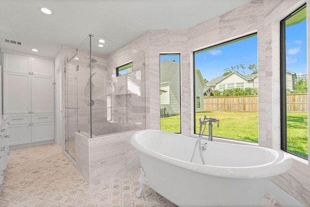 bathroom featuring independent shower and bath and tile walls