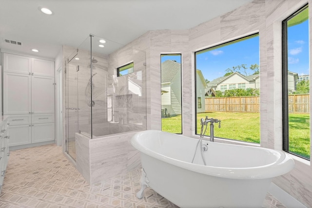 5658 Del Monte Dr, Houston, TX 77056 - bathroom featuring plenty of natural light, a stall shower, a freestanding bath, and recessed lighting