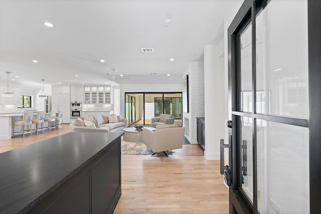 living room with ceiling fan and light hardwood / wood-style floors