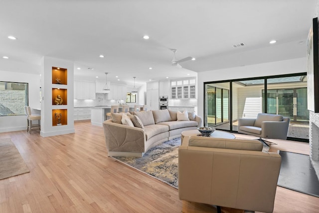 living room with ceiling fan and light hardwood / wood-style floors