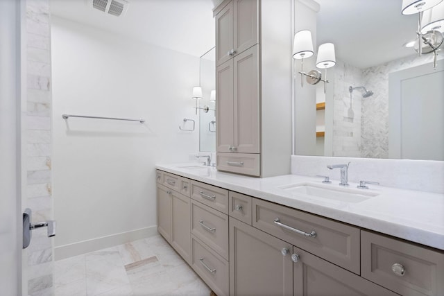 bathroom with a tile shower and vanity