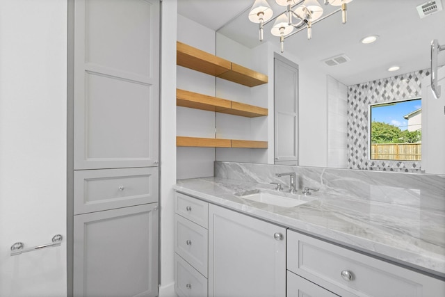 bathroom with an inviting chandelier and vanity