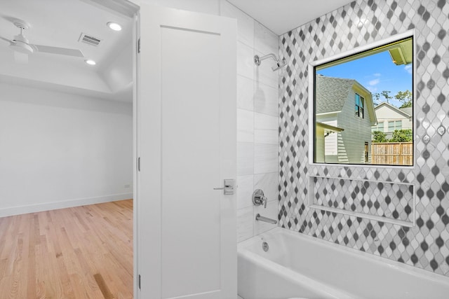 bathroom featuring ceiling fan, tiled shower / bath, and wood-type flooring