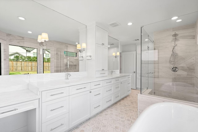 bathroom with vanity and shower with separate bathtub