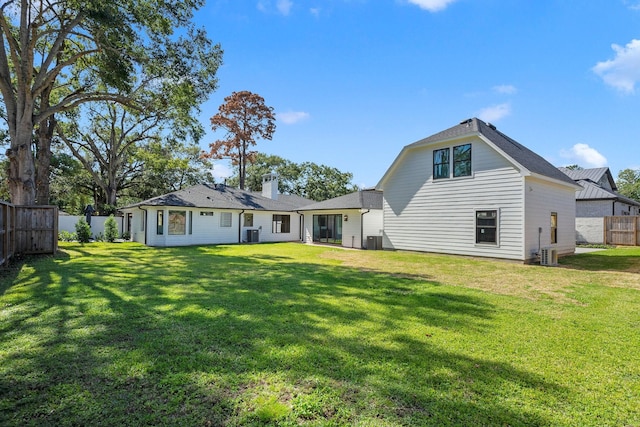 back of house featuring a lawn and central AC unit