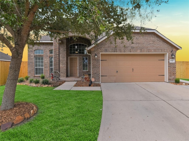 view of front of home with a garage and a lawn