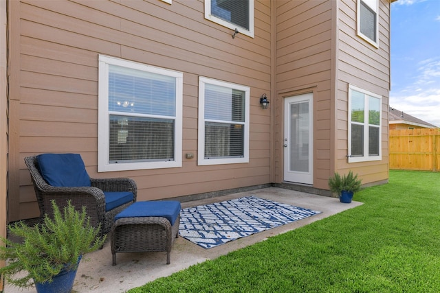 view of exterior entry featuring a yard and a patio