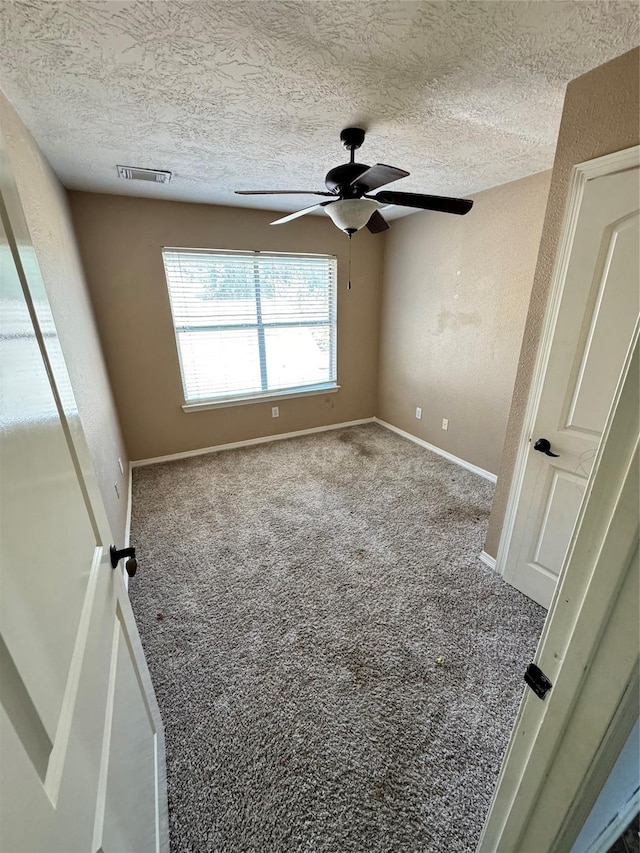 spare room with ceiling fan, carpet floors, and a textured ceiling