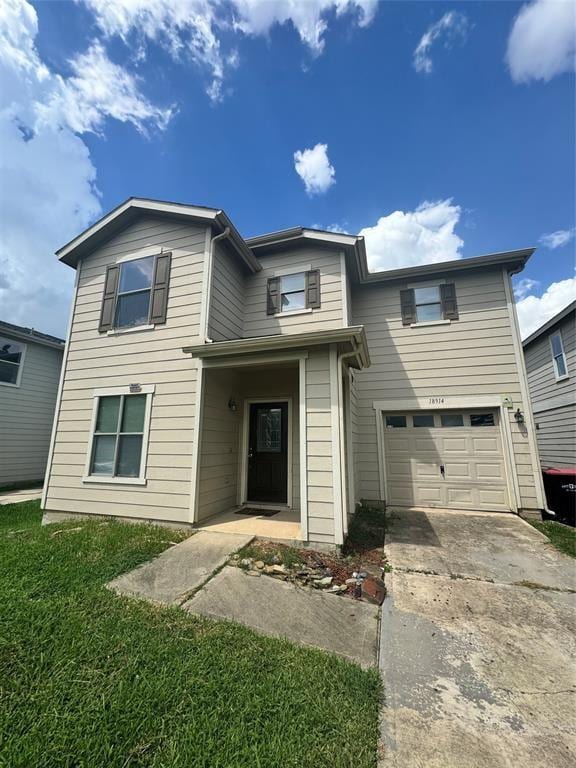 view of property with a garage and a front lawn