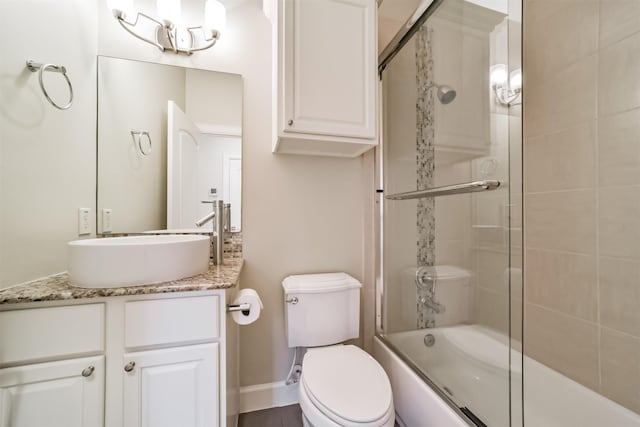 full bathroom with toilet, bath / shower combo with glass door, and vanity