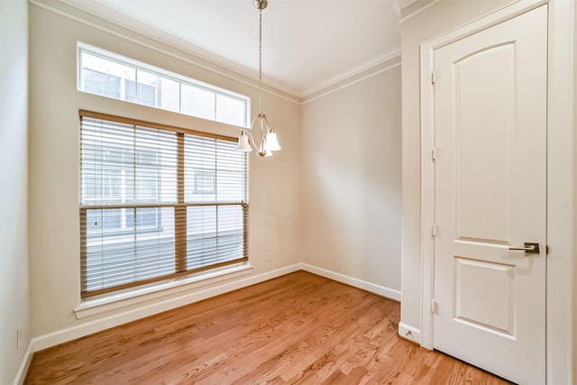 unfurnished room featuring crown molding, an inviting chandelier, and light hardwood / wood-style floors