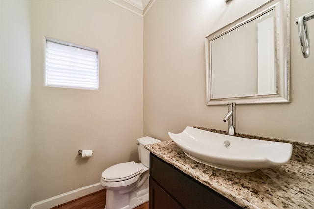 bathroom featuring toilet, crown molding, hardwood / wood-style floors, and vanity