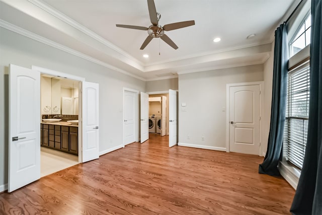 unfurnished bedroom featuring ensuite bath, ceiling fan, independent washer and dryer, and light wood-type flooring