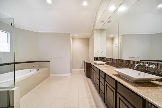 bathroom featuring tiled bath, vanity, crown molding, and tile patterned flooring