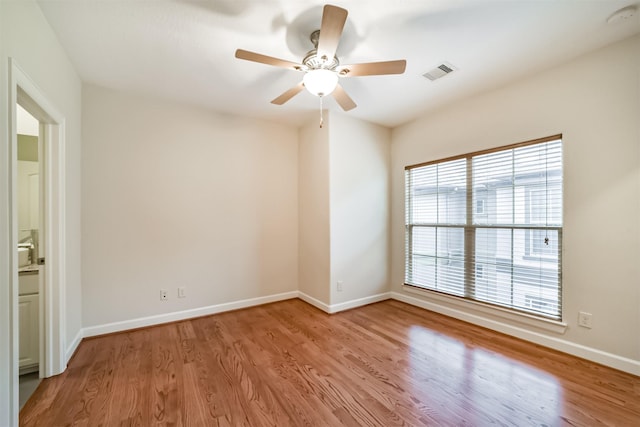 empty room with light wood-type flooring, ceiling fan, and a healthy amount of sunlight