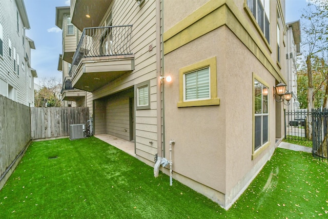 view of property exterior featuring cooling unit, a balcony, and a yard