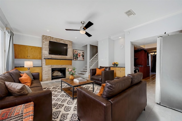 tiled living room with ceiling fan, ornamental molding, and a fireplace