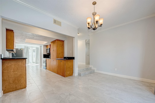 kitchen with hanging light fixtures, ornamental molding, stainless steel appliances, and a notable chandelier