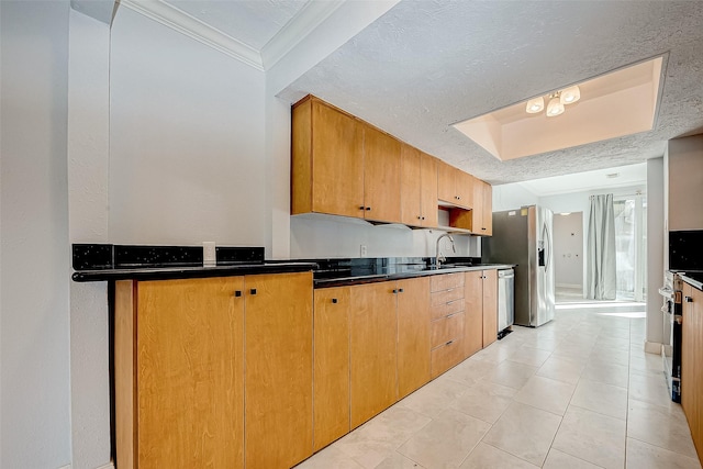 kitchen featuring appliances with stainless steel finishes, sink, crown molding, and a textured ceiling