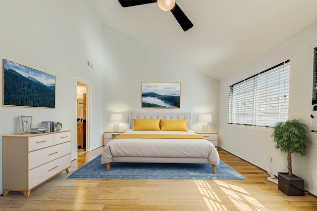 bedroom featuring ceiling fan, light hardwood / wood-style flooring, and high vaulted ceiling