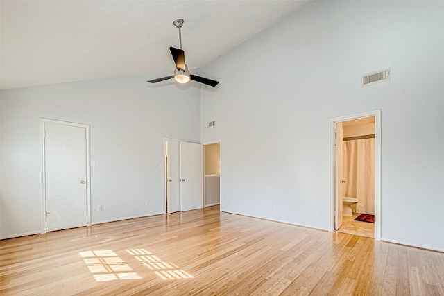 unfurnished bedroom featuring ceiling fan, ensuite bathroom, light hardwood / wood-style floors, and high vaulted ceiling