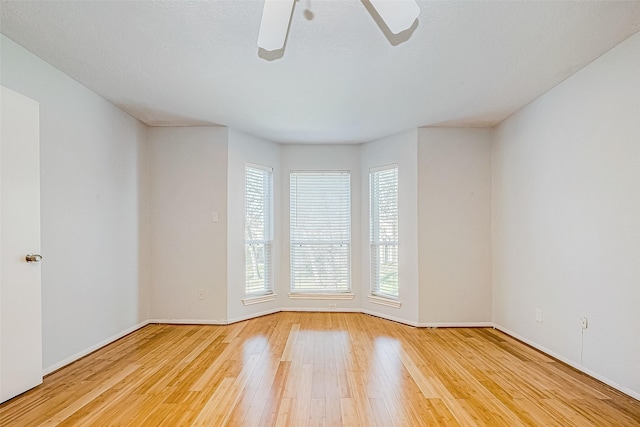 spare room with ceiling fan and light wood-type flooring