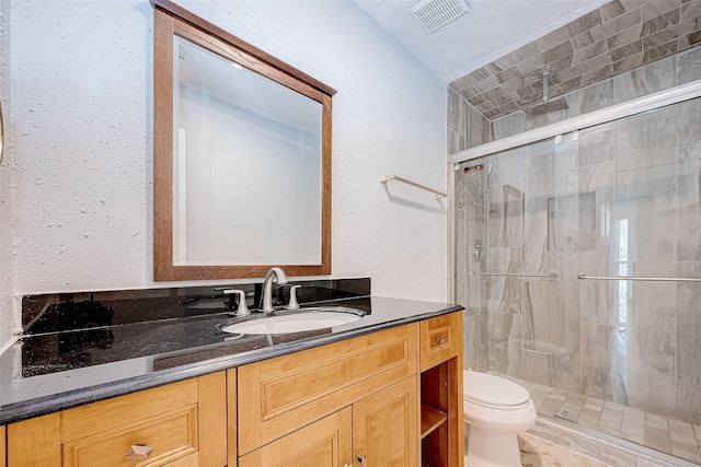 bathroom with toilet, walk in shower, and vanity