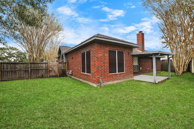 back of property featuring a patio and a yard