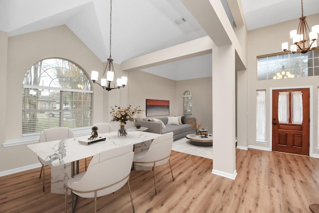 dining area featuring vaulted ceiling, a chandelier, and light hardwood / wood-style floors