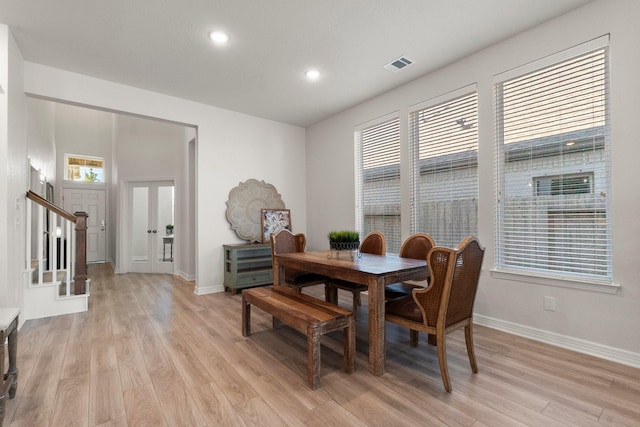 dining room featuring french doors, a healthy amount of sunlight, and light hardwood / wood-style floors