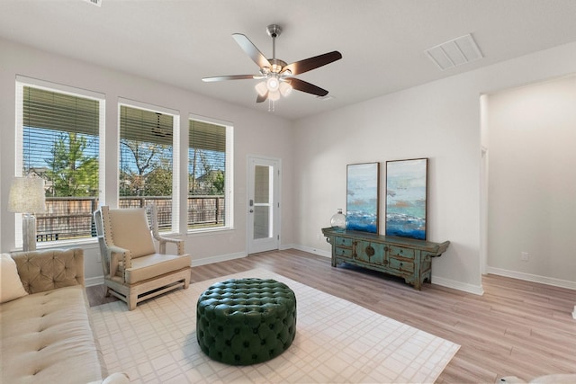 living area with ceiling fan and light wood-type flooring