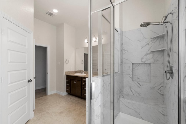 bathroom featuring tile patterned flooring, vanity, and a shower with shower door