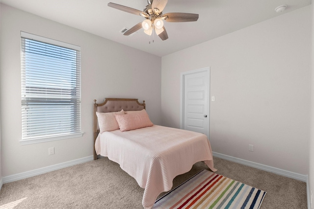 bedroom with ceiling fan, light carpet, and multiple windows