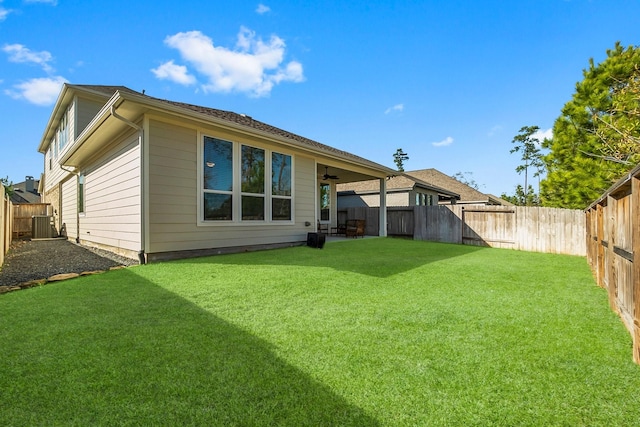 rear view of property featuring cooling unit and a lawn