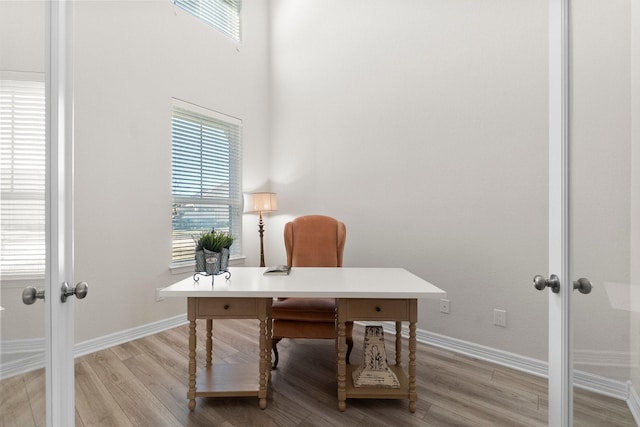 office featuring french doors and light hardwood / wood-style flooring